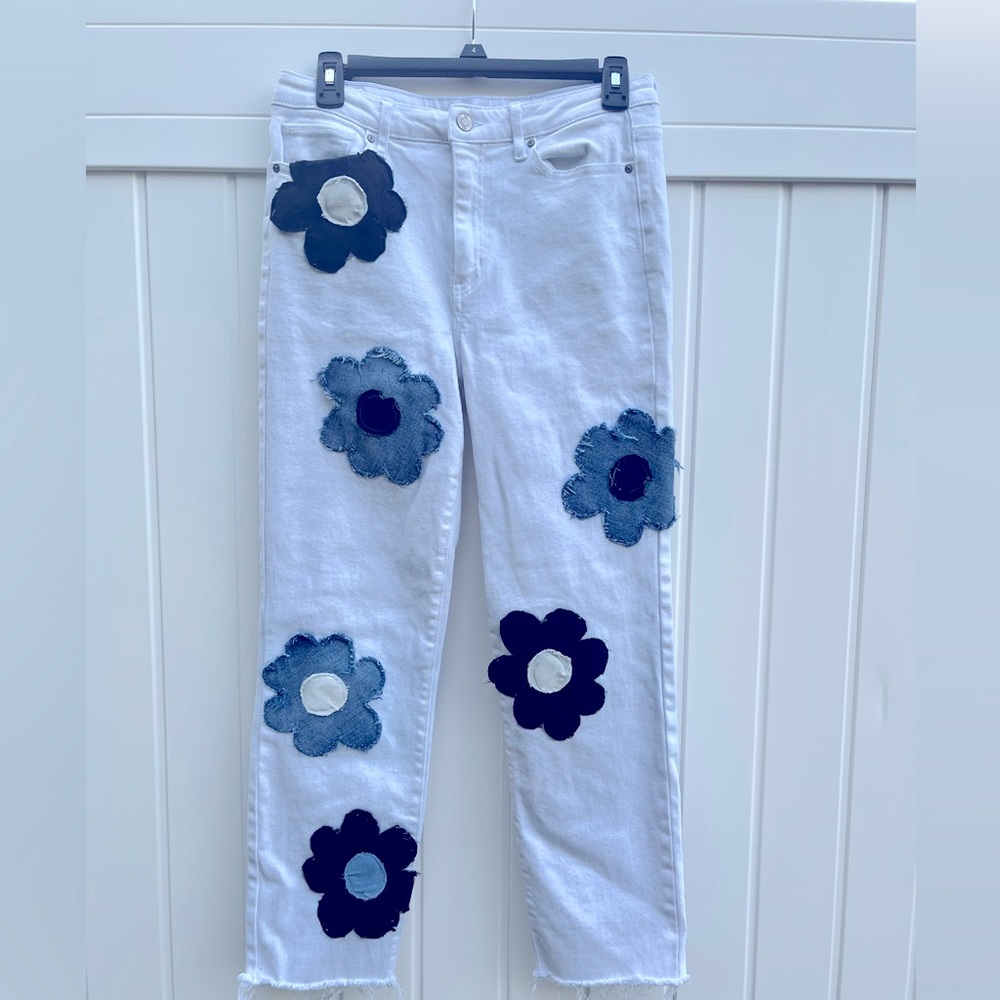 White jeans with denim patches in shape of flowers on them, size is women’s 9/29
